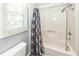 A bathroom with a shower and a window with blinds letting in natural light at 1561 Montclair St, Charleston, SC 29407