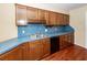 Wood cabinets and blue countertops surround a double sink in this eat-in kitchen at 1561 Montclair St, Charleston, SC 29407