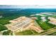 An aerial view displays a new community development near a highway, surrounded by expansive green areas at 166 Yarrow Way, Moncks Corner, SC 29461