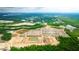An aerial view reveals a vibrant new community near a highway, with homes surrounded by lush greenery at 166 Yarrow Way, Moncks Corner, SC 29461