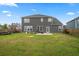 Spacious backyard with well-maintained lawn, patio area, and a view of the home's exterior at 180 Basket Grass Ln, Summerville, SC 29486
