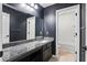 Dark bathroom with large mirror over granite vanity and shower-tub combination at 180 Basket Grass Ln, Summerville, SC 29486