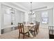Elegant dining room with tray ceilings, showcasing a chandelier, neutral walls, and a seamless transition to other spaces at 180 Basket Grass Ln, Summerville, SC 29486