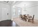 Bright dining room with neutral walls and carpet, features a classic chandelier and large windows for ample natural light at 180 Basket Grass Ln, Summerville, SC 29486