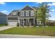 Two-story home with attached garage, manicured lawn, and a tree on the front yard, showcasing suburban living at 180 Basket Grass Ln, Summerville, SC 29486