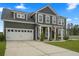 Traditional two-story home with attached garage, features manicured lawn, driveway, and neutral color scheme at 180 Basket Grass Ln, Summerville, SC 29486