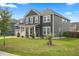 Traditional two-story home featuring a well-kept lawn and mature tree landscaping, creating a welcoming curb appeal at 180 Basket Grass Ln, Summerville, SC 29486