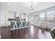 Bright kitchen with white cabinets, a kitchen island, stainless appliances, hardwood floors, and an adjacent eating area at 180 Basket Grass Ln, Summerville, SC 29486