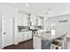 Modern kitchen boasts white cabinets, granite counters, stainless steel appliances, and an island with bar seating at 180 Basket Grass Ln, Summerville, SC 29486