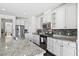 Well-lit kitchen featuring white cabinets, stainless steel appliances, granite countertops, and dark mosaic backsplash at 180 Basket Grass Ln, Summerville, SC 29486