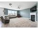 Spacious living room with a cozy fireplace, large windows, carpet, ceiling fan, and comfortable seating arrangements at 180 Basket Grass Ln, Summerville, SC 29486