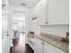 Bright mudroom features convenient storage cabinets with granite countertops and bench with coat hooks at 180 Basket Grass Ln, Summerville, SC 29486
