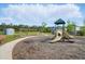 A community playground featuring a slide and swings with a shed and seating area at 180 Basket Grass Ln, Summerville, SC 29486