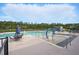 Community pool featuring lounge chairs, tables, and a splash pad under a blue sky at 180 Basket Grass Ln, Summerville, SC 29486