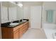 Traditional bathroom with double sink vanity, dark countertops, and a doorway leading to the tub at 187 Pecan Dr, Summerville, SC 29483