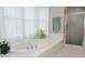 Relaxing bathroom showcasing a soaking tub, a plant, a tiled deck, and a glass-enclosed shower at 187 Pecan Dr, Summerville, SC 29483