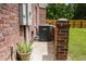 Air conditioning unit nestled on a red brick wall beside a privacy fence, showcasing outdoor maintenance and property line at 187 Pecan Dr, Summerville, SC 29483