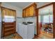 Functional laundry area with a washer and dryer, overhead cabinetry, and access to the dining room at 1925 Belgrade Ave, Charleston, SC 29407