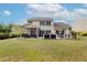 Backyard showcasing a patio with screened porch, outdoor dining, stone fireplace, and spacious lawn at 1996 Wild Indigo Way, Hanahan, SC 29410
