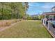 Large backyard with wood fence and patio featuring screened porch, outdoor kitchen, and fireplace at 1996 Wild Indigo Way, Hanahan, SC 29410