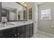 Bathroom featuring dark cabinets, a white countertop, decorative artwork, and large mirror at 1996 Wild Indigo Way, Hanahan, SC 29410