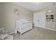 Well-lit Bedroom featuring a charming crib, floral decorations, and ample closet space at 1996 Wild Indigo Way, Hanahan, SC 29410