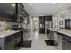 Modern kitchen features stainless steel appliances, granite countertops, dark cabinetry, and tile flooring at 1996 Wild Indigo Way, Hanahan, SC 29410