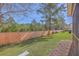 Green backyard with lush grass, a wooden fence, and mature trees at 2001 Poplar Grove Pl, Summerville, SC 29483
