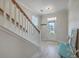 Bright foyer featuring wood-look floors, a white staircase with wood banister, and natural light at 2001 Poplar Grove Pl, Summerville, SC 29483