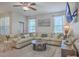 Bright living room featuring a large sectional sofa, ceiling fan, and mounted TV at 2001 Poplar Grove Pl, Summerville, SC 29483