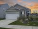 Charming single-Gathering home features manicured lawn, two car garage and craftsman style architecture at sunset at 215 Sweet Cherry Ln, Summerville, SC 29486