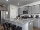 Modern kitchen with stainless steel appliances, a gray island, and granite countertops at 215 Sweet Cherry Ln, Summerville, SC 29486