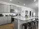A modern kitchen features gray cabinets, stainless appliances, and an island with barstool seating at 215 Sweet Cherry Ln, Summerville, SC 29486
