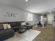 Open-concept living room and dining area with dark gray sofa and wood-look floors at 215 Sweet Cherry Ln, Summerville, SC 29486
