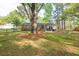 A spacious backyard with a patio, fire pit, and mature trees creates a serene outdoor experience at 2158 Till Rd, Charleston, SC 29414