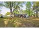 Large backyard with a patio, fire pit, and mature trees, creating a private and inviting outdoor space at 2158 Till Rd, Charleston, SC 29414