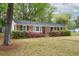 Charming single-story home with brick facade, dark shutters, and colorful landscaping enhances curb appeal at 2158 Till Rd, Charleston, SC 29414