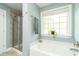 Bright bathroom with a soaking tub and a glass-enclosed shower next to a window at 2160 Pentland Dr, Charleston, SC 29412