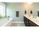 Bright bathroom features a soaking tub, double vanity with dark cabinets, and a neutral color scheme at 2160 Pentland Dr, Charleston, SC 29412