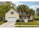 Inviting yellow home with a white garage door and a cozy front porch with palm trees at 225 Hanahan Plantation Cir, Hanahan, SC 29410