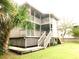 Charming multi-story house with open balconies, wooden stairs, and a well-maintained lawn at 229 Linkside Villas # 1/3 Share, Edisto Beach, SC 29438