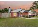 Charming single-story brick home featuring a well-manicured lawn and cozy front porch at sunset at 234 Two Hitch Rd, Goose Creek, SC 29445