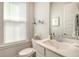 Powder room has chrome fixtures, mirror, and a window with blinds at 2383 Lenwick Hall Ln, Johns Island, SC 29455
