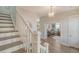 Bright foyer with staircase and view of a study through french doors with a light fixture at 2383 Lenwick Hall Ln, Johns Island, SC 29455