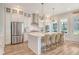 Bright kitchen features stainless steel appliances, white cabinets, subway tile backsplash, and island with bar stool seating at 2383 Lenwick Hall Ln, Johns Island, SC 29455