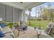 Relaxing screened porch with comfortable seating, outdoor rug, and view of the landscaped backyard at 2383 Lenwick Hall Ln, Johns Island, SC 29455