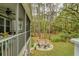 Screened-in porch overlooking backyard, showcasing a paver patio with fire pit and seating in a woodsy setting at 2856 Claybrook St, Johns Island, SC 29455