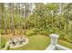 Backyard stone patio with inviting fire pit and seating nestled amongst the tall trees at 2856 Claybrook St, Johns Island, SC 29455