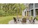 Home's backyard features a paver patio with fire pit, enhanced by lush landscaping and wooded backdrop at 2856 Claybrook St, Johns Island, SC 29455