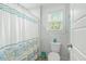 Cozy bathroom featuring a shower with a patterned curtain, a toilet, and a window for natural light at 2856 Claybrook St, Johns Island, SC 29455